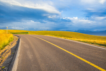 Asphalt road highway and yellow grass with mountains nature landscape in autumn. Road trip.