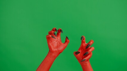 Creepy halloween devil monster hand in red paint with black nails crawling with both hands,...