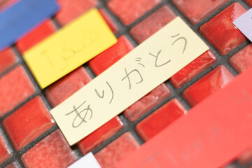 Expression of thanks in Japanese, surrounded by notes with “Thank you” in different languages, highlighted on shiny mosaics.