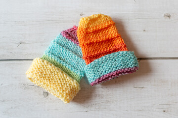 hand knitting little baby mittens in bright colours with copy space 