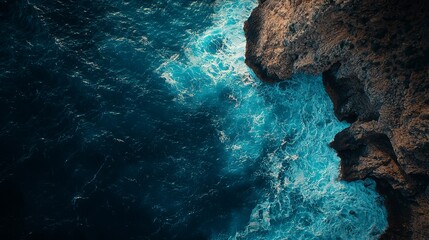 Dramatic ocean waves crashing against rugged cliffs with deep blue water
