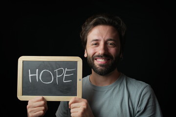 Happy Caucasian Man holding a Chalkboard with the Handwritten word  