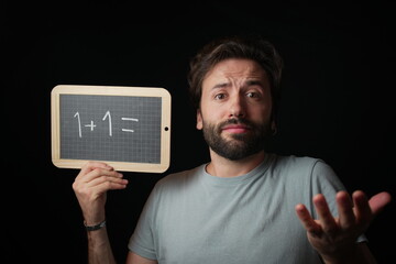 Man holding a Chalkboard with Handwritten "1+1="