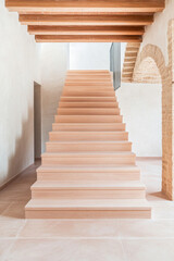 Fototapeta premium Modern wooden staircase features minimalist design and natural light in a spacious interior setting during the daytime