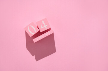 Pink wooden calendar blocks displaying February 4th on a minimalist pink background