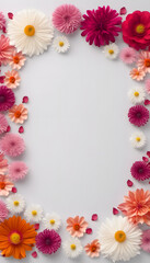 A blank white card surrounded by a vibrant arrangement of flowers. The flowers create a colorful border around the card, ideal for invitations or greeting cards.