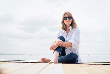 Full length of a blond haired woman relaxing by the lake