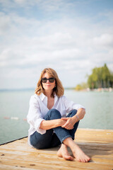 Full length of a blond haired woman relaxing by the lake