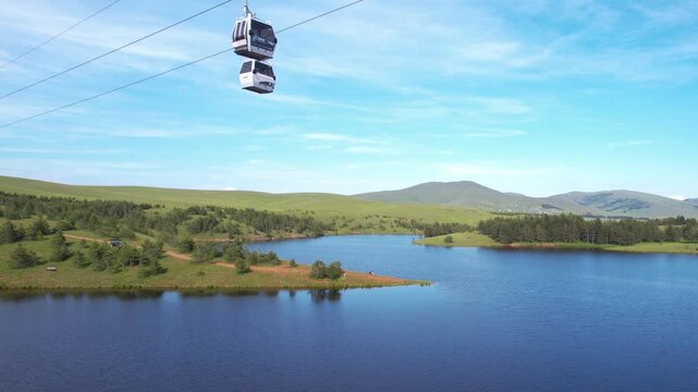 Drone Shot of Lake and Gondola Lift Cabins in Mountain Landscape on Sunny Summer Day. Zlatibor Serbia