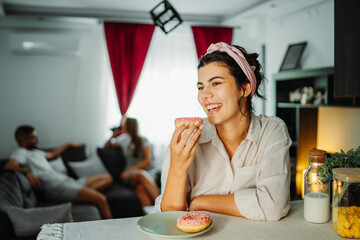 Young caucasian woman eating donuts for breakfast