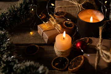 Christmas gifts and ornaments illuminated by candlelight.