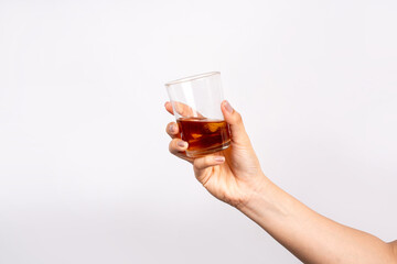 Hand holding glass with whiskey isolated on white background. Alcohol concept