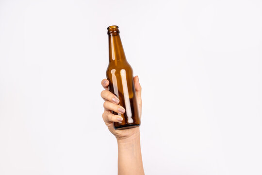 Photo of woman's hand holding bottle of beer isolated on white background. Alcohol concept