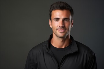 Fototapeta premium Portrait of a satisfied man in his 30s wearing a sporty polo shirt over blank studio backdrop
