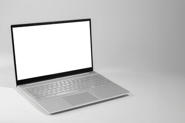 A laptop with a white screen sits on a white surface