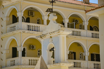 Yellow and white façade of a building with balconies in Zante