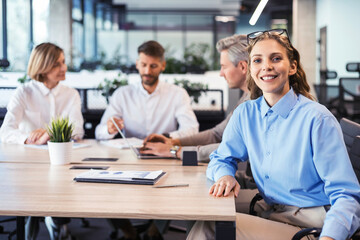 Business woman with her staff, people group in background at modern bright office indoors.