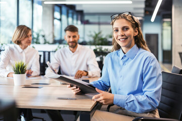 Business woman with her staff, people group in background at modern bright office indoors.