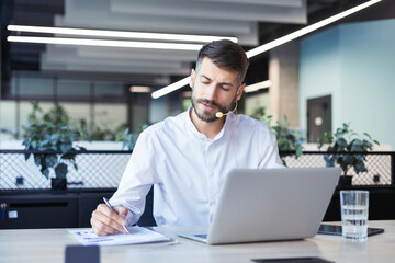 Happy young male customer support executive working in office.