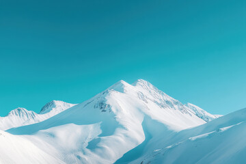 Stunning snow-capped mountain under clear blue sky, serene winter landscape.