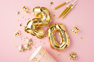 Festive 20th birthday setup with golden balloons and decorations on a pink background celebrating a...