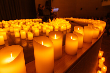 blurred symphonic orchestra on stage with lots of candles