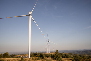 Obraz premium Wind turbines in a scenic, mountainous landscape, harnessing renewable energy from the wind, symbolizing sustainability and eco-friendly technology