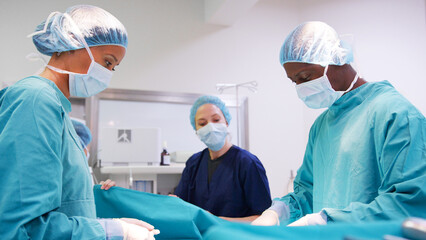 Multi-Cultural Surgical Team Working On Patient In Hospital Operating Theatre