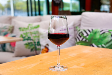 A glass of red wine on restaurant table. 