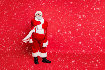 Full length photo of minded fat overweight santa claus bad guy with his hands crossed big abdomen choose naughty kids wear eyeglasses isolated over red background