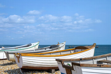 Obraz premium boats on the beach at Selsey West Sussex England with fishing boats in the sea in the background