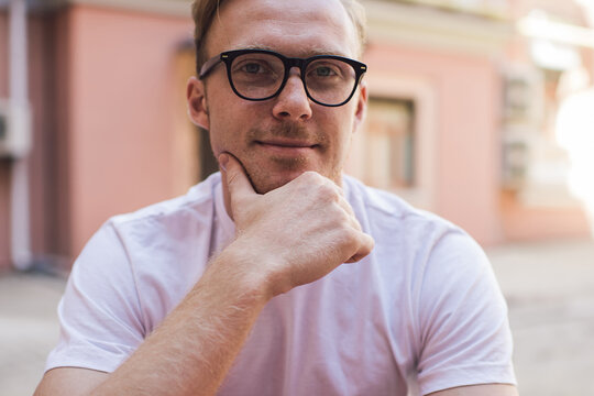 Portrait of Caucasian male blogger looking at camera while using digital tablet for messaging in web social networks, millennial young man pondering on app connection and online notification