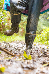 Child in welly boots, jump, jumping in mud.