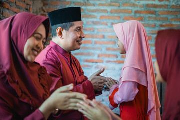 Asian Muslim families shake hand and forgiving each other during eid mubarak celebration at home