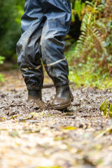 Child in welly boots, jump, jumping in mud.