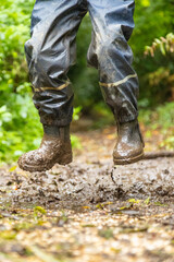 Child in welly boots, jump, jumping in mud.