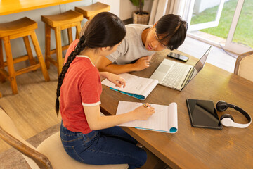 Studying together, two students using laptop and notebooks  table