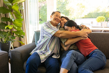 Obraz premium Family hugging and smiling on couch, enjoying quality time together