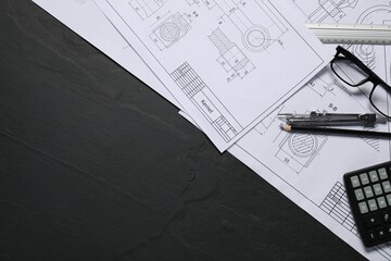 Different engineering drawings, pencil, divider and calculator on grey textured table, flat lay....