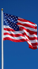 Obraz premium American flag waving against clear blue sky, symbolizing freedom and unity
