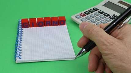 DAY single word written on wooden cubes with green background and office stationery.