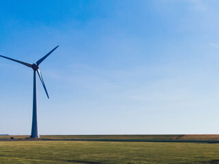 Aerial view of huge modern windmills with turbines powered with wind power providing ecological energy on rural environment during summer day. Line of turbines producing electricity