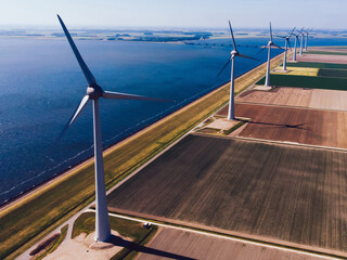 Birds eye view of windmills station with green energy resources generation from wind power on scenic vast area of agriculture fields.Alternative electricity production with rotating turbines in meadow