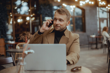 Young beard man using laptop on office, freelance work, outdoor close up hipster portrait, brutal, guy listening music on earphones, make photo and video, production, Bali, coffee cup, smartphone