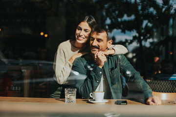 Couple enjoying a warm afternoon together in a cozy cafe, sharing smiles and laughter over coffee while seated by a large window
