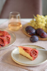 Plum pie upside down on white wooden table