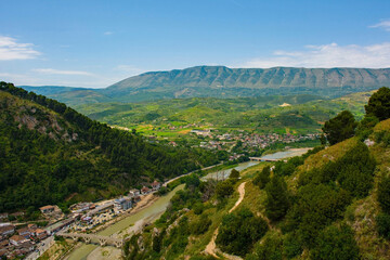 Obraz premium View of Gorica quarter of Berat, Albania taken from Berat Castle. UNESCO listed, known as City of a 1000 Windows. Mali Partizan Mountain left, Osum river crossed by Gorica Bridge foreground. 