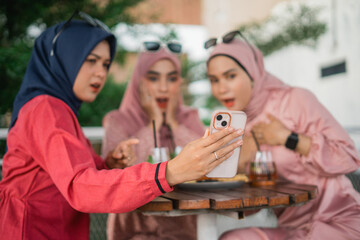 Excited friends joyfully discovering something fascinating and interesting on their phone together