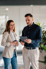Office staff with tablet discussing digital paperwork on tablet at office