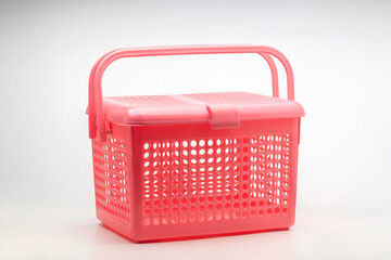 Pink plastic basket with lid on white background